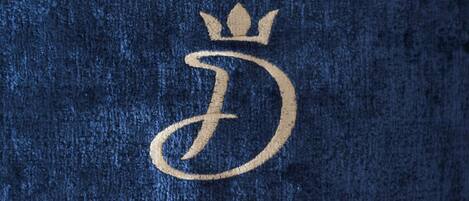 A close-up of a textured fabric with a gold embroidered emblem.