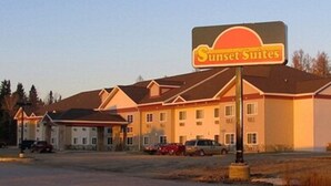 A hotel named Sunset Suites with a prominent sign, multiple buildings, and parked cars in front. - Sunset Inn and Suites (Sioux Lookout)