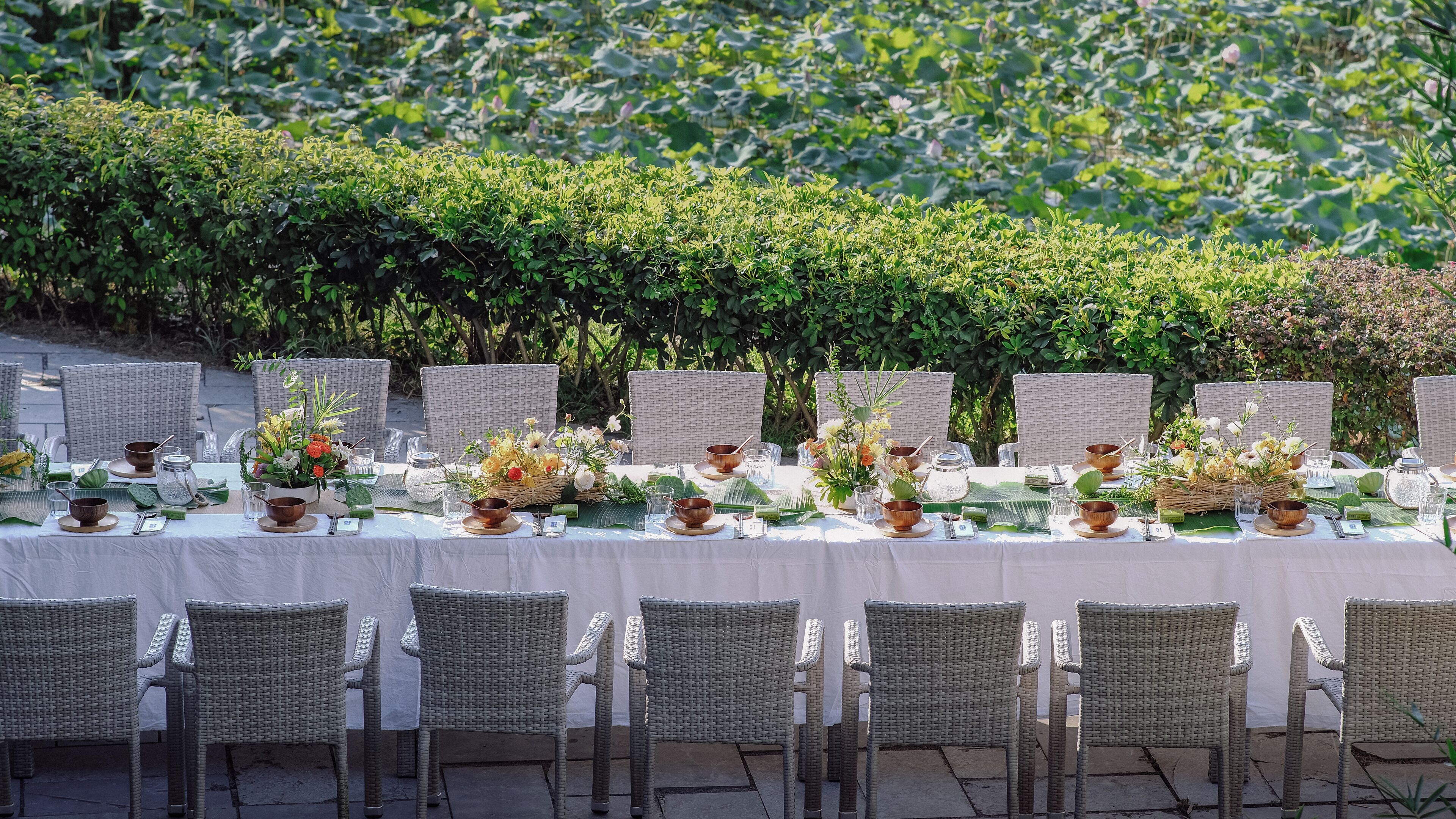 A dining table set with wicker chairs, arranged for a meal.
