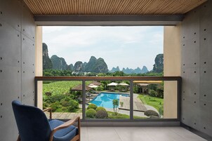 A modern room with a large window overlooking a pool and garden.