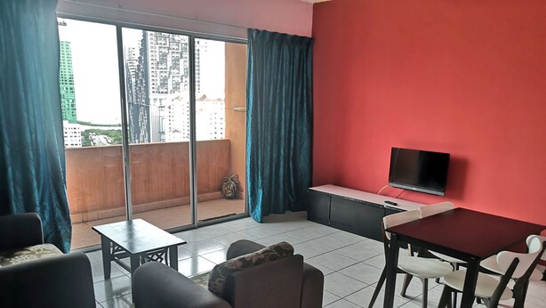 A modern living room with a red wall, a TV, a dining table with chairs, a sofa, and a balcony with curtains. - Globallon Hotel Apartment (Malacca City)