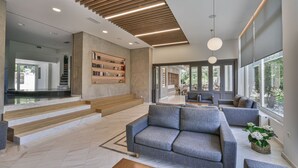 Un salon moderne avec un canapé gris, une table basse et une bibliothèque.