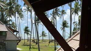 A balcony with a view of palm trees and the ocean. - Pontal dos Carneiros Beach Bungalows (Tamandaré)