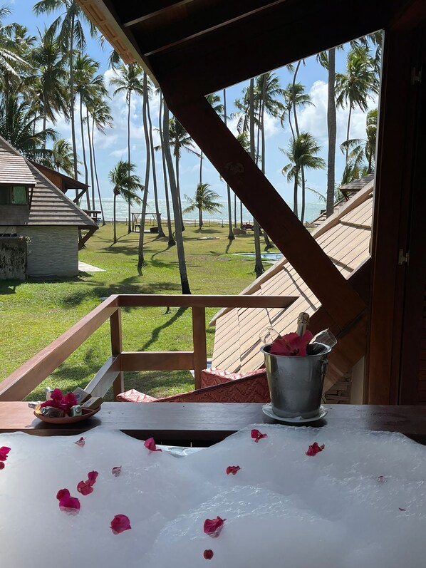A balcony with a view of palm trees and the ocean. - Pontal dos Carneiros Beach Bungalows (Tamandaré)