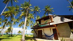 A beachfront property with a wooden structure, a hammock, and palm trees. - Pontal dos Carneiros Beach Bungalows (Tamandaré)
