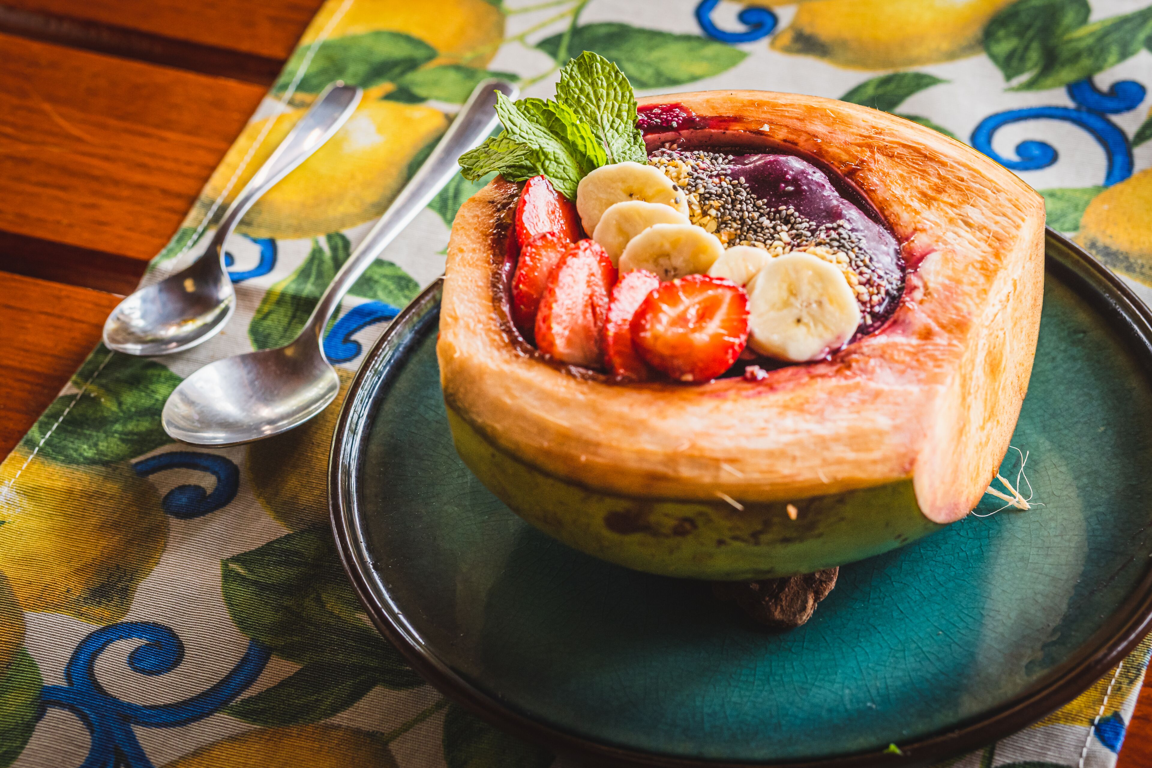 A dessert on a plate with a spoon and a fork beside it.