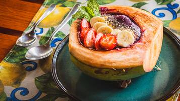 A dessert on a plate with a spoon and a fork beside it.
