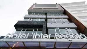 Un moderno edificio de hotel con un letrero destacado que dice "Hotel Inter Bogota".