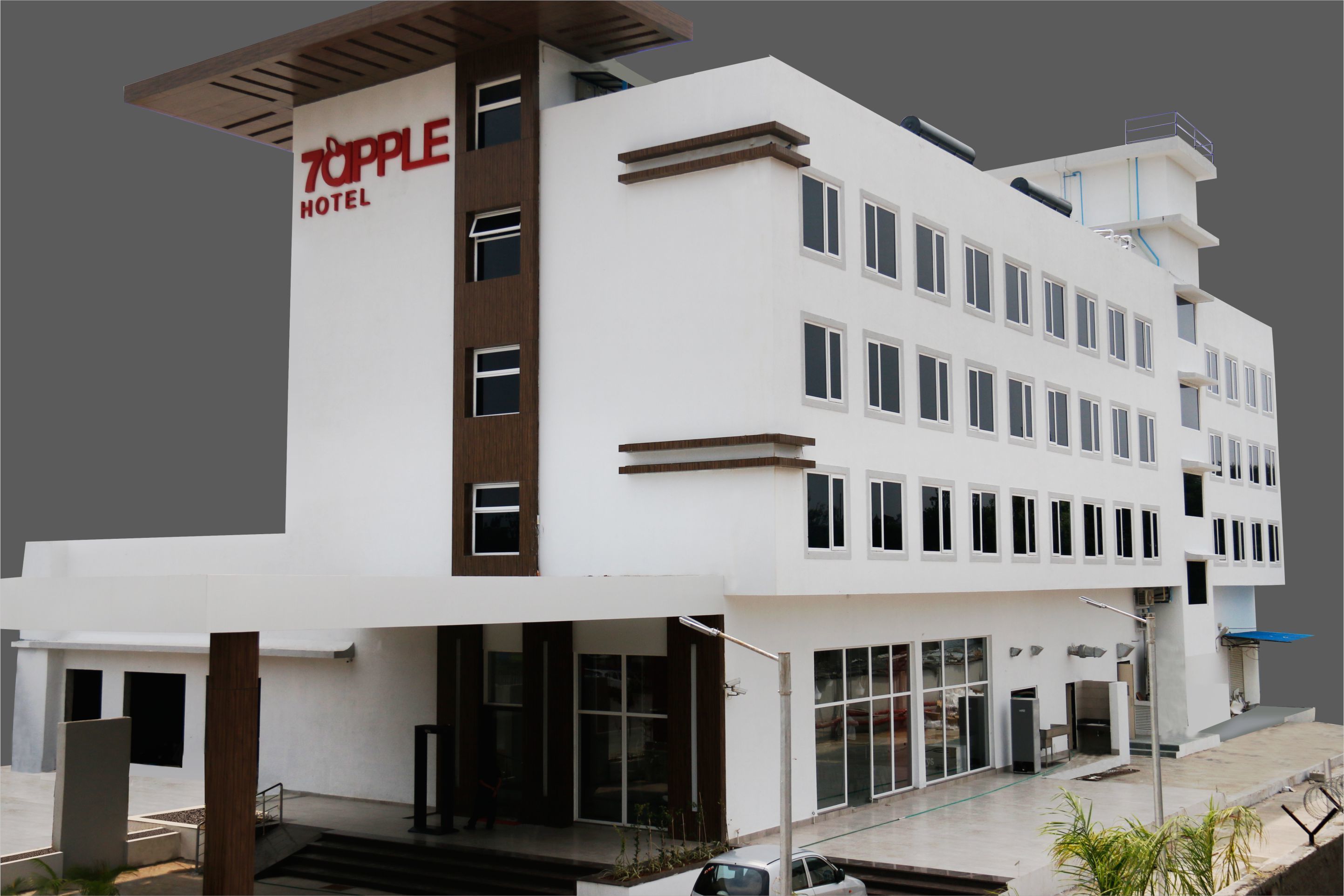 Un hotel moderno con fachada blanca, varios pisos y un llamativo letrero 'Topple Hotel'.