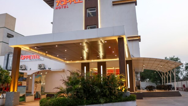Ein modernes Hotel mit einem gut sichtbaren Schild, auf dem 'Topple Hotel' steht, und ein direkt angrenzendes Restaurant namens 'Cappetite'.