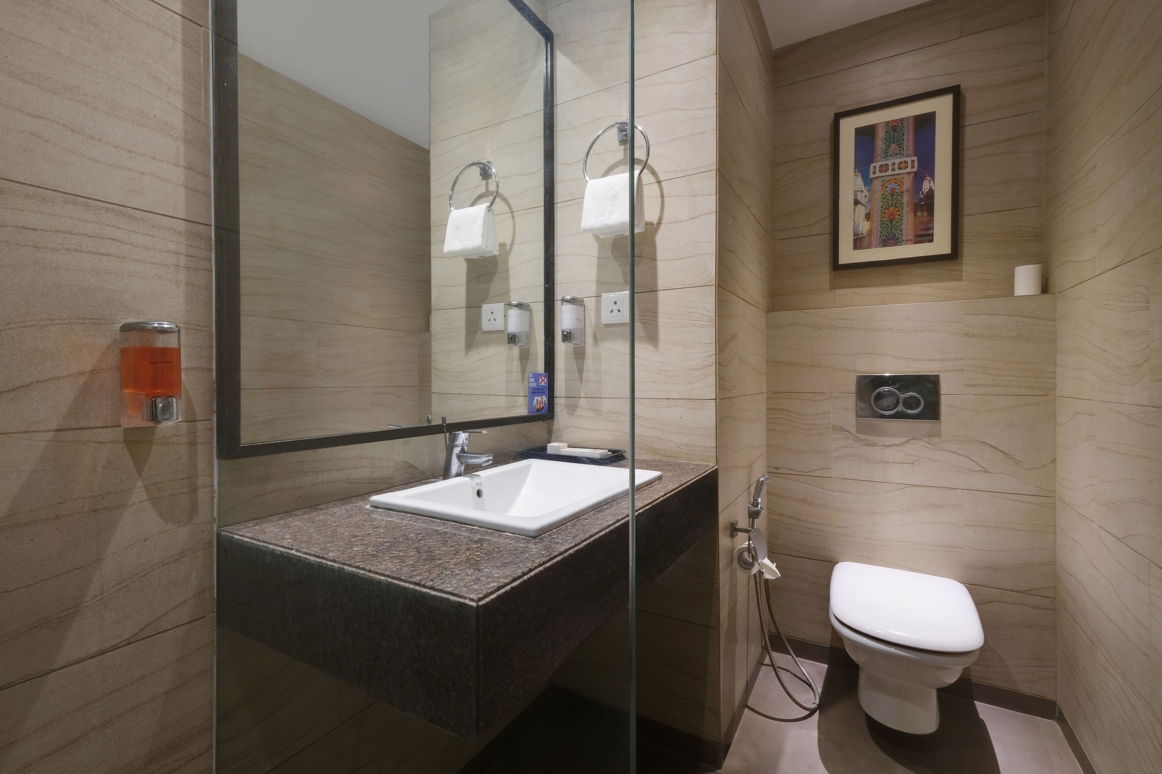Un bagno moderno con doccia vetrata, lavandino bianco e water.