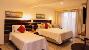 A hotel room with two beds, a flat-screen TV, and artwork on the walls. - Hotel Ferraz (Pouso Alegre)