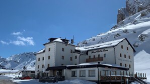 A large, multi-story building with a snow-covered roof and a sign reading "Hotel Col d'Isere." - Hotel Col Di Lana (Canazei)