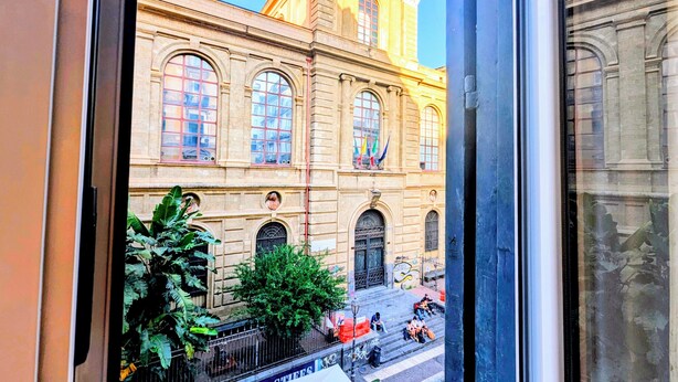 Um edifício com grandes janelas e uma entrada central.