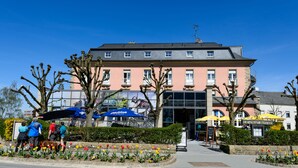 Um hotel com fachada rosa, várias janelas e entrada visível.