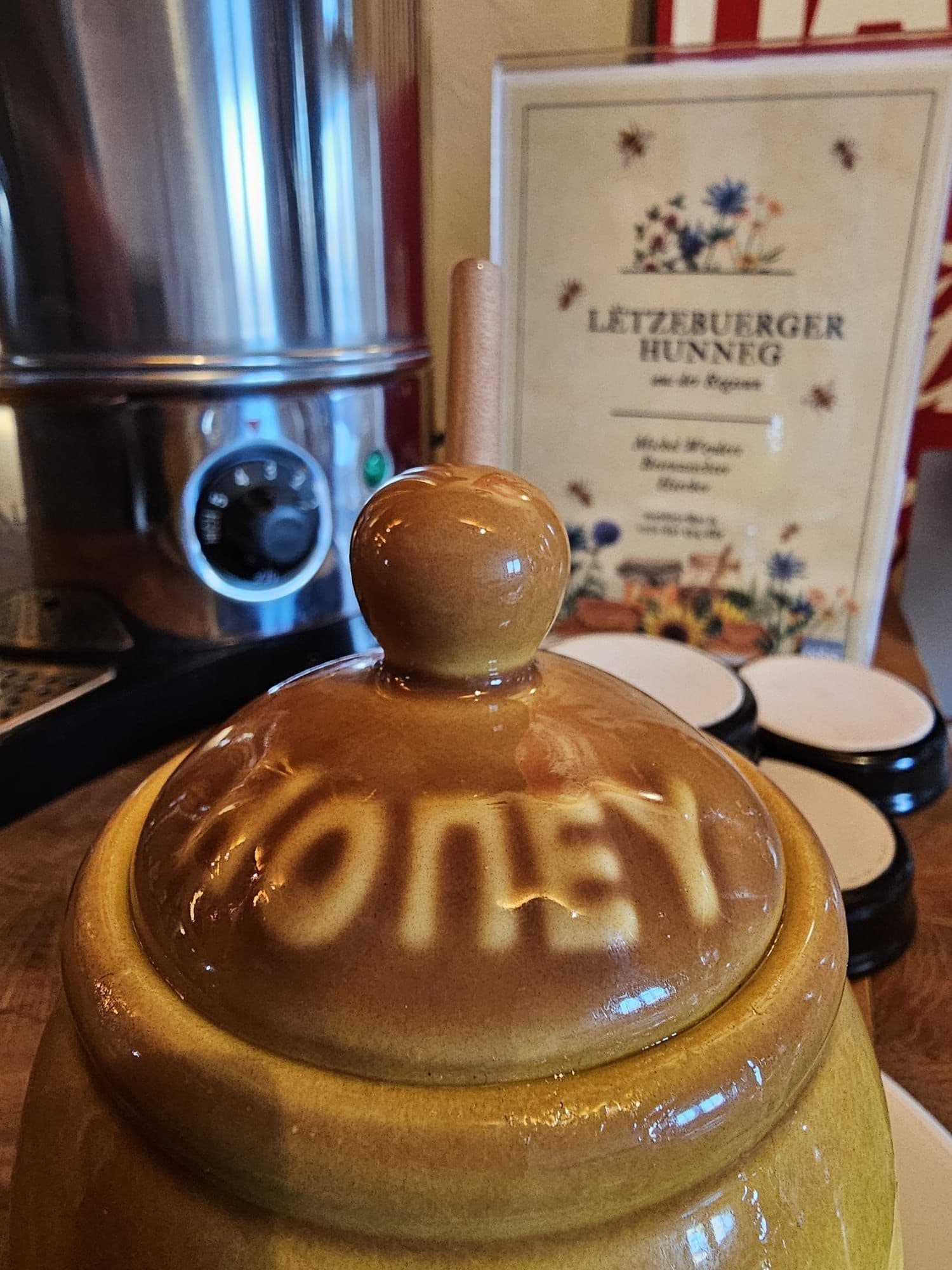 A honey jar with a lid on a wooden surface.