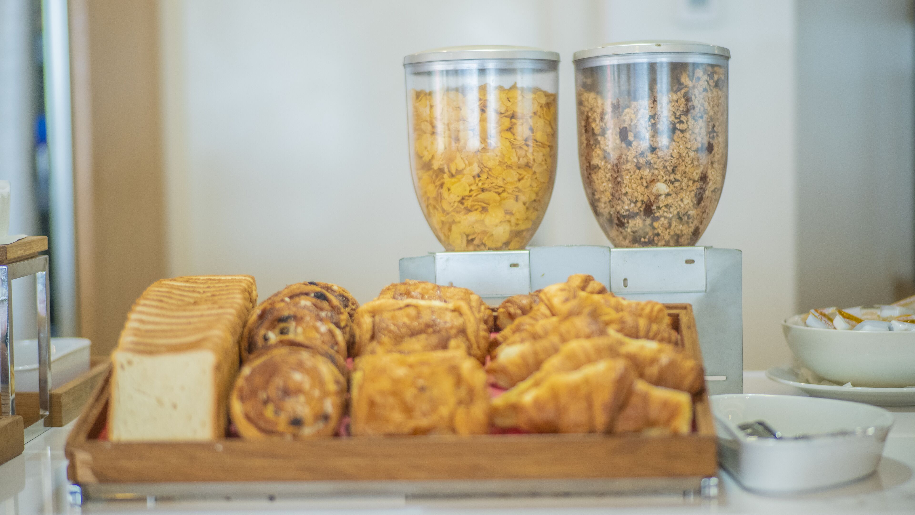 A breakfast buffet with various pastries and cereals.