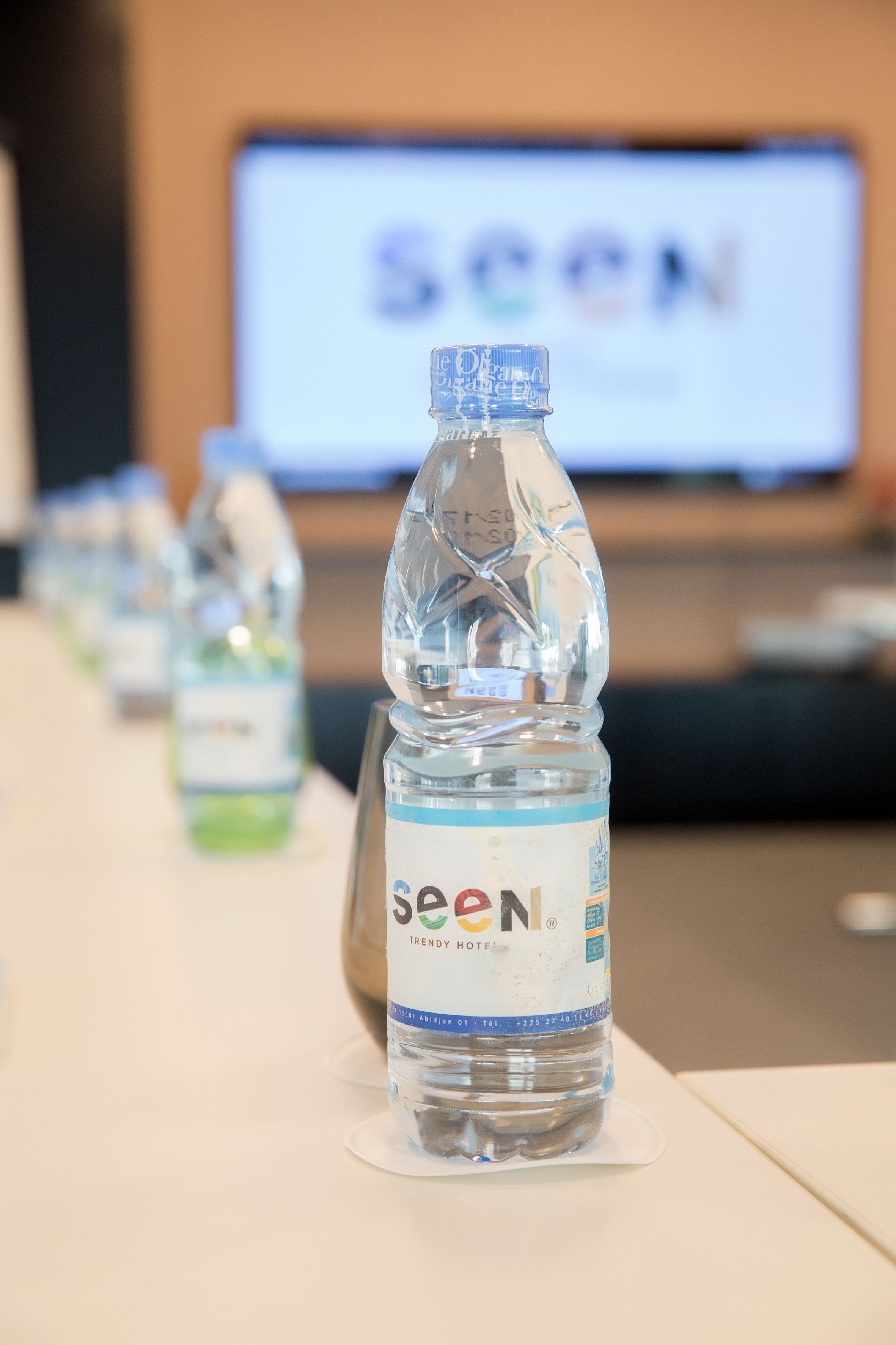 A bottle of water with a label that reads "seen trendy hotel."