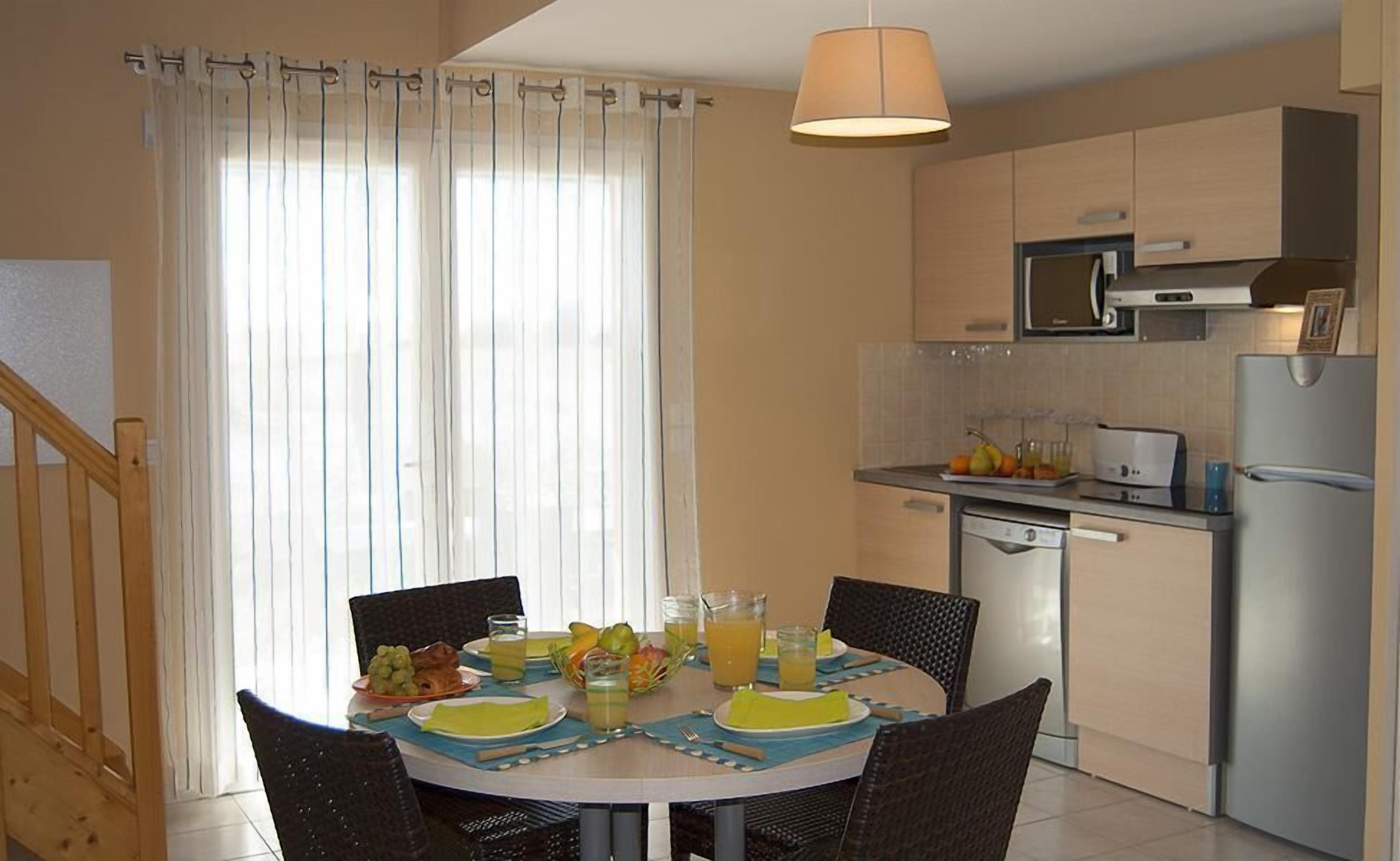A modern kitchen with a dining area.