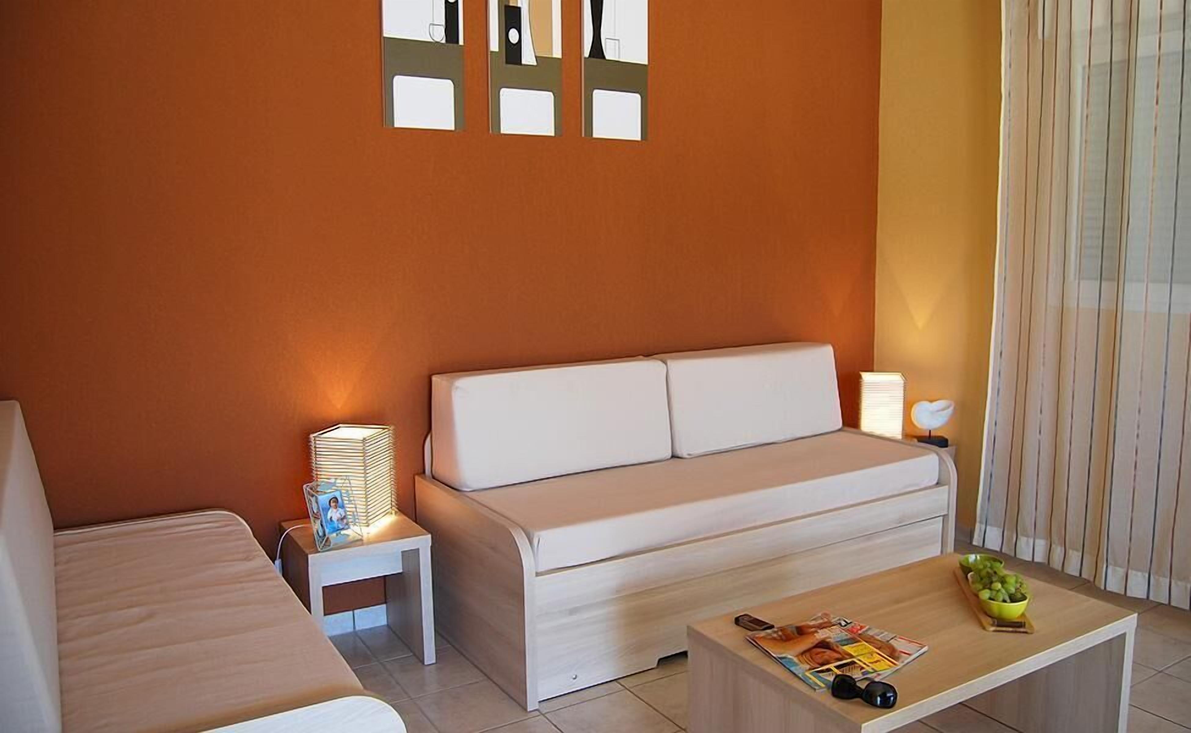 A modern living room with a sofa, a coffee table, and a side table with a lamp.