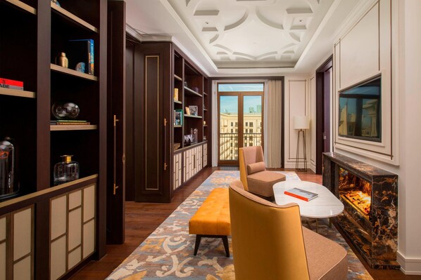 A hotel room with a large window, a fireplace, a sofa, a coffee table, and a bookshelf. - The St. Regis Astana (Astana)