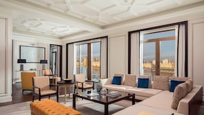 A spacious living room with a large sofa, armchairs, a coffee table, and a view of the city through large windows. - The St. Regis Astana (Astana)
