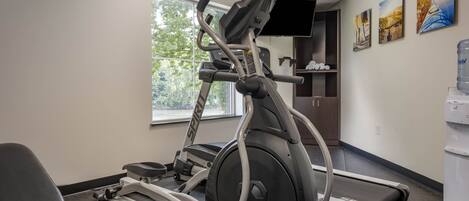 A gym with cardio equipment, a treadmill, and a stationary bike.