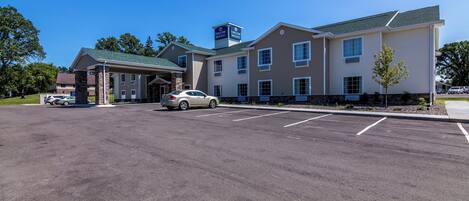 A hotel with a covered parking area, multiple entry points, and a sign indicating it is a Courtyard by Marriott.