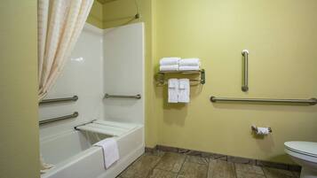 A bathroom with a bathtub, a shower, a toilet, and a towel rack with towels.