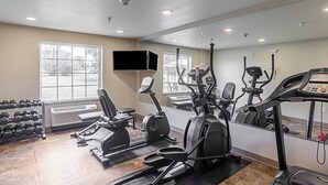 A gym with cardio machines, dumbbells, and a large mirror. - Cobblestone Inn & Suites - Guernsey (Guernsey)