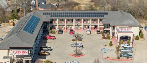 Un hotel con estacionamiento, paneles solares y varias edificaciones.