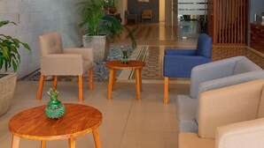 Un vestíbulo amplio con techo alto, muebles modernos y una gran pantalla de televisión.
