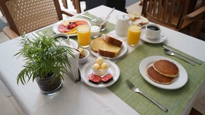 A breakfast table with various food items, a pitcher, and a plant. - El Hotel Business Class – Zamora Centro (Zamora)