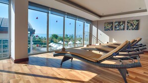 A sunlit room with large windows, wicker lounge chairs, and artwork on the walls. - Akra Sorgun Tui Blue Sensatori - All Inclusive  (Manavgat)