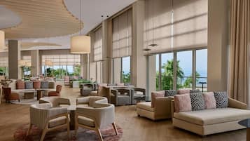 A spacious lobby with multiple seating areas, large windows, and a view of the outdoors.