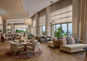 A spacious lobby with multiple seating areas, large windows, and a view of the outdoors. - Akra Sorgun Tui Blue Sensatori - All Inclusive  (Manavgat)