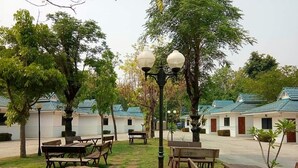 A courtyard with outdoor seating, lamp posts, and small trees. - Fahproundfon Hotel (Nakhon Ratchasima)