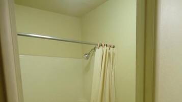 A bathroom with a bathtub, toilet, and a shower curtain.