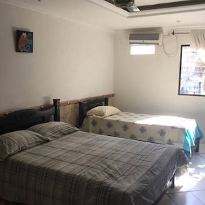 Habitación triple, baño privado | Tabla de planchar con plancha, camas supletorias, wifi gratis