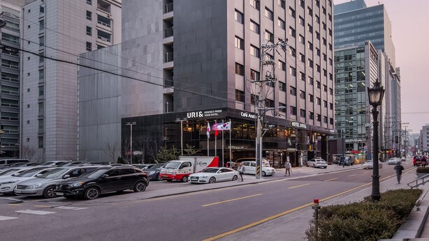 Edifici d'hotel URIS de disseny modern, amb un senyal distintiu que diu 'URIS HOTEL' a la façana.