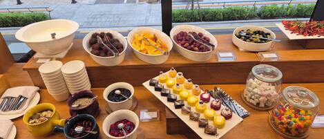 A buffet with various food items and utensils.