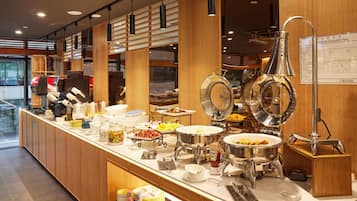 A buffet setup with various food items and serving utensils.