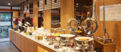 A buffet setup with various food items and serving utensils.