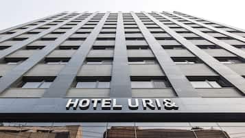 Un edificio de hotel alto de diseño moderno, con un letrero llamativo que dice 'HOTEL URIN'.