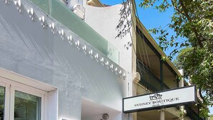 A Sydney Boutique Hotel with a white facade, large windows, and a balcony with lace railings. - Sydney Boutique Hotel (Darlinghurst)