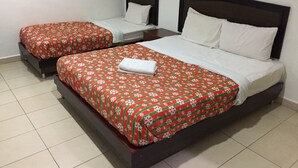 A hotel room with two single beds and a larger bed.