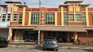 A hotel with a sign reading "All Star Hotel" and a visible contact number.