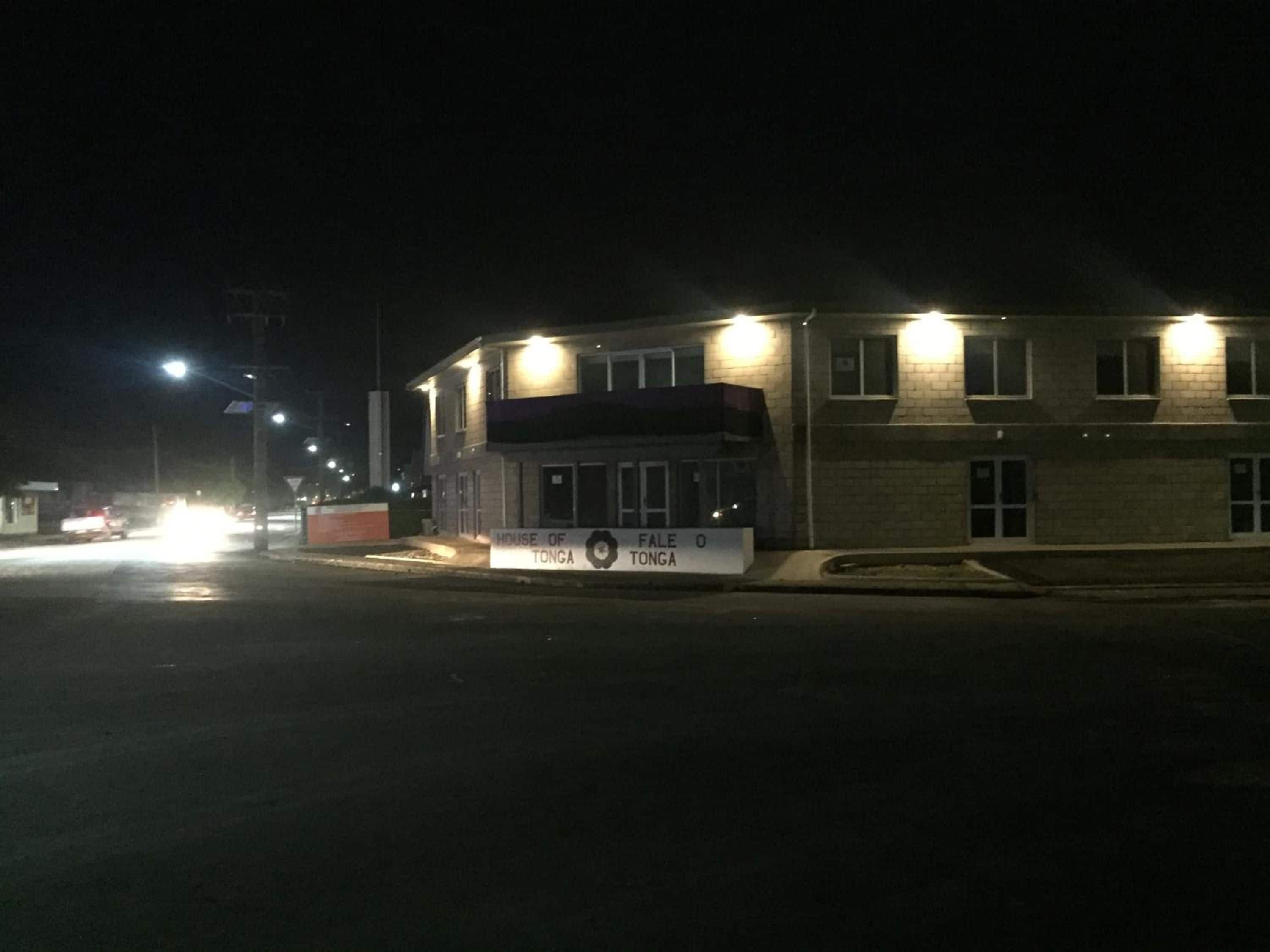 A building with a sign that reads 'House of Tonga' at night.