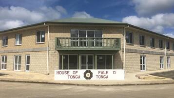 Un bâtiment à deux étages, sur lequel on peut lire l’inscription « HOUSE OF TONGA », et qui possède un balcon.
