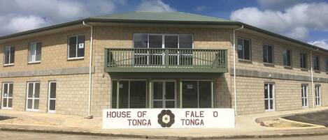 Un bâtiment à deux étages, sur lequel on peut lire l’inscription « HOUSE OF TONGA », et qui possède un balcon.